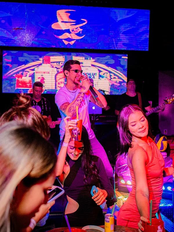 Convidados em volta do palco durante show da banda em casa noturna