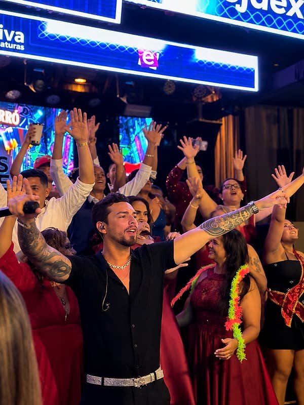 Matheus Rhauny de braços abertos com os formandos cantando junto